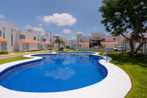 TlayecacにあるFamily House with Water Park Tlayecac, 3 Bedroomsの遊び場付きの庭にある大きなスイミングプール
