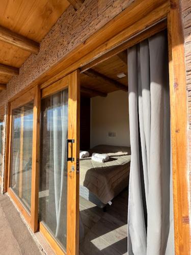 a sliding glass door to a bedroom with a bed at Gaucho Mendoza in Malargüe