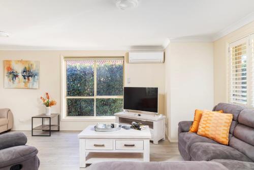 a living room with a couch and a tv at Pawprints in Corlette