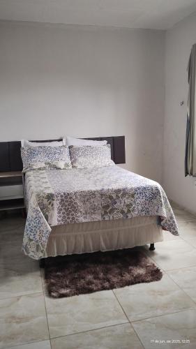 a bedroom with a bed with a blanket and pillows at New House Temporada in João Pessoa