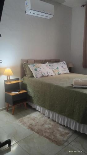 a bedroom with a bed and a night stand with a lamp at New House Temporada in João Pessoa