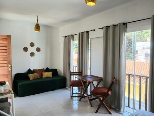 a living room with a green couch and a table at 2 COCO BAMBU PIPA apto 2, a 200 metros da praia e a 100 metros do centro in Pipa