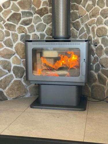 a stove with a fire in a stone wall at Radcliffe Retreat and Spa Cottage Port Arthur in Port Arthur