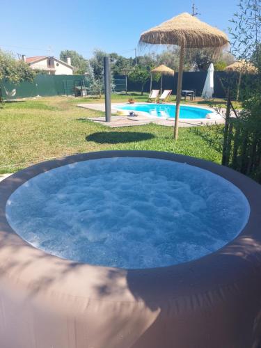 a large pool of blue water with an umbrella at Casas Zé Pinto in Hospital