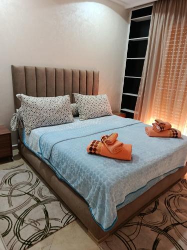 two pairs of slippers sitting on a bed in a bedroom at Appartement Deluxe à côté de souq elhad in Agadir