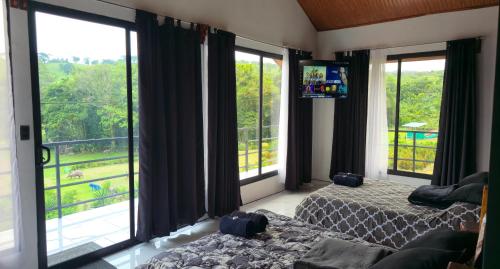 a bedroom with two beds and large windows at La Florida Lodge in Tilarán