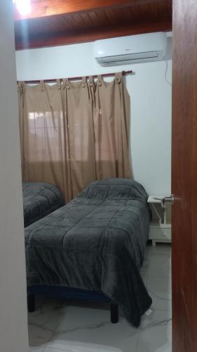 a bedroom with a bed and a window with a curtain at Alojamiento Lindo Amanecer in Mercedes