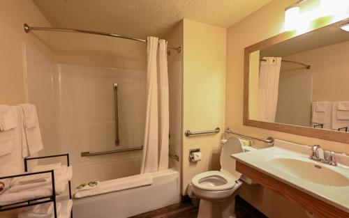 a bathroom with a sink and a toilet and a mirror at Sunset Bay Resort & Suites in Wisconsin Dells