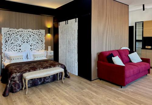a bedroom with a bed and a red couch at FORTUNA ORO Luxury Stay in Verona