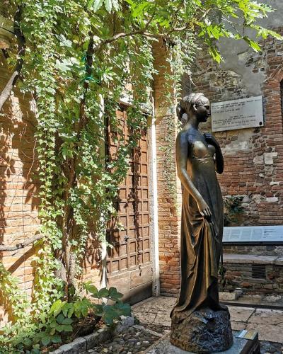a statue of a woman standing in front of a building at FORTUNA ORO Luxury Stay in Verona