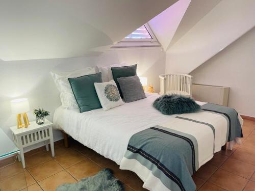una camera da letto con un letto con cuscini verdi e bianchi di Appartement vue panoramique mer et piscine a Sainte-Anne