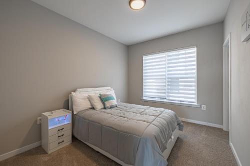 a small bedroom with a bed and a window at Spacious 4BR House with Private Garage in Washington