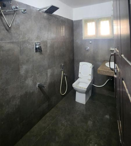 a bathroom with a toilet and a shower at Bangalore Chalet in Bangalore