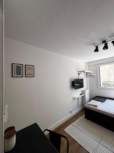 une chambre blanche avec un lit et une fenêtre dans l'établissement Nice appartement for 2 adults with air-conditioning, à Nice