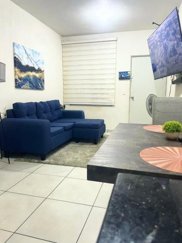 a living room with a blue couch and a table at Ubicado en coto privado a 5km de Nuevo Vallarta in Mezcales