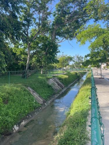a river in a park with a green fence at Ubicado en coto privado a 5km de Nuevo Vallarta in Mezcales