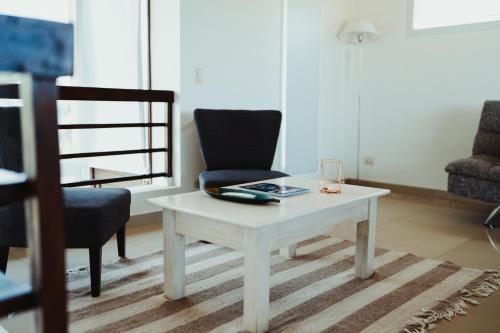 a living room with a white coffee table and a chair at Casa Pampa Cabañas in Chapadmalal