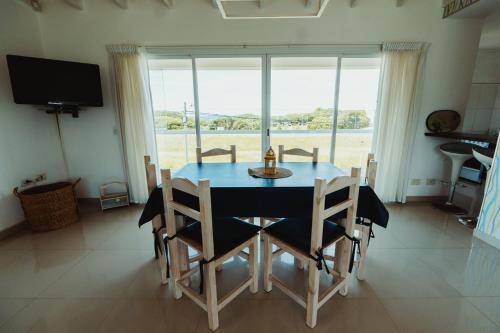 a dining room with a table and chairs and a window at Casa Pampa Cabañas in Chapadmalal