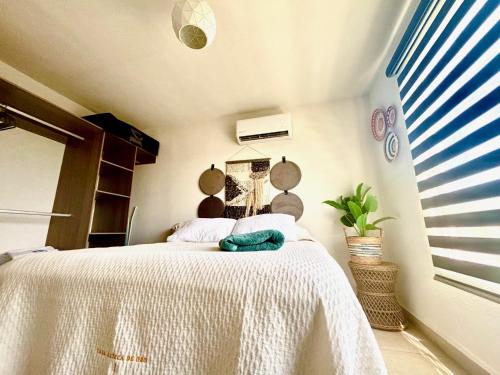 a bedroom with a bed with a white blanket at Departamento Boutique con más Amenidades que Ningún otro en la Zona in Acapulco