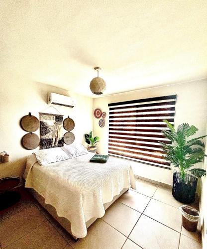a bedroom with a bed and a large window at Departamento Boutique con más Amenidades que Ningún otro en la Zona in Acapulco