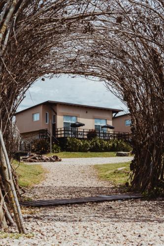 an archway over a dirt road in front of a house at Casa Pampa Cabañas in Chapadmalal