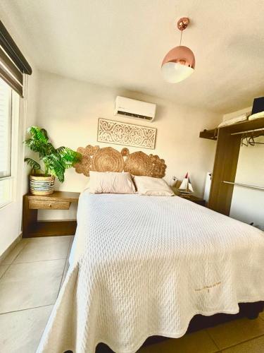 a bedroom with a bed with a white bedspread at Departamento Boutique con más Amenidades que Ningún otro en la Zona in Acapulco