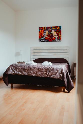a bed in a bedroom with a wooden floor at Casa Pampa Cabañas in Chapadmalal