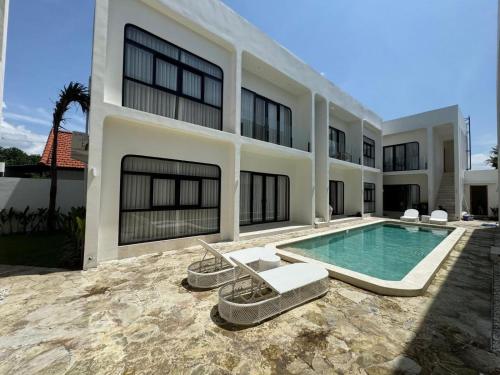 a large house with a swimming pool in front of it at Nelayan Reef Apartment in Mantaak