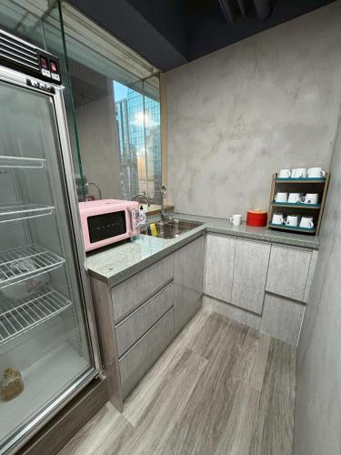 a kitchen with a sink and a pink microwave at Formosa 101 Taipei Main Branch in Taipei