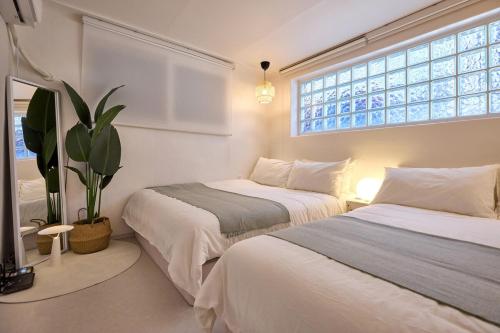 Un dormitorio con dos camas y una planta en maceta. en Stay Luna, en Seúl