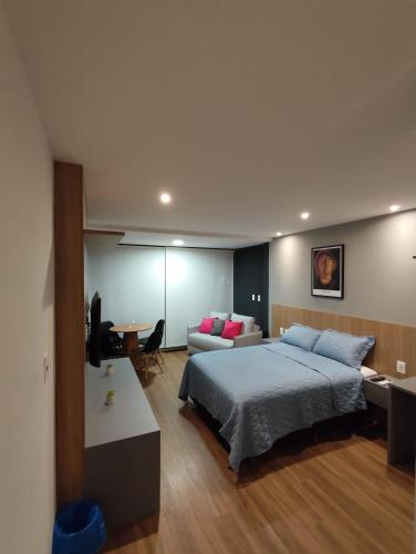 a bedroom with a large bed and a couch at Art Stúdio Beira-Mar em Armação 123 in Salvador