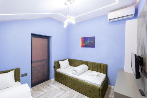 a room with two beds in a room with blue walls at Caspian Colorful Villas in Lankaran