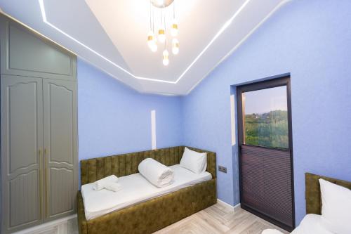 a bedroom with blue walls and a bed with white pillows at Caspian Colorful Villas in Lankaran