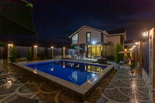 a swimming pool in front of a house at night at Caspian Colorful Villas in Lankaran
