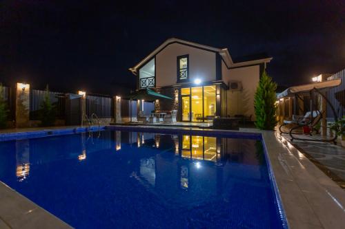 a swimming pool in front of a house at night at Caspian Colorful Villas in Lankaran