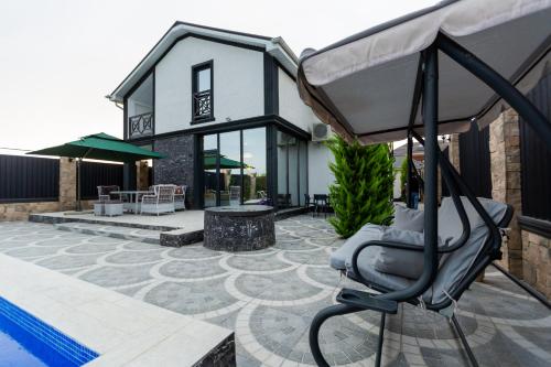 a house with a swimming pool and a chair at Caspian Colorful Villas in Lankaran