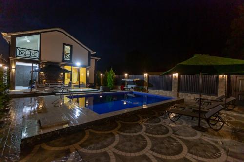 a house with a swimming pool at night at Caspian Colorful Villas in Lankaran