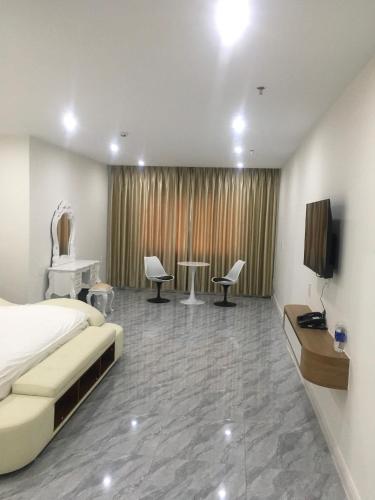 a bedroom with a bed and a tv and chairs at DONG PHUONG HOTEL in Bao Loc