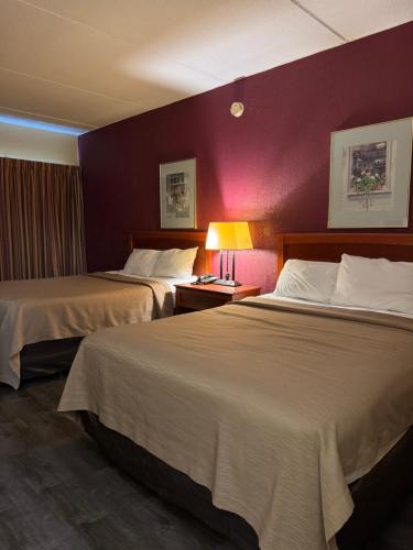 a hotel room with two beds and a purple wall at Motel Sun Inn in Winthrop Harbor