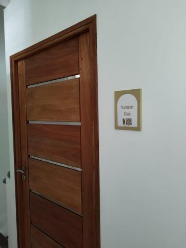 a wooden door with a sign on a wall at Nature bay in Pointe-à-Pitre