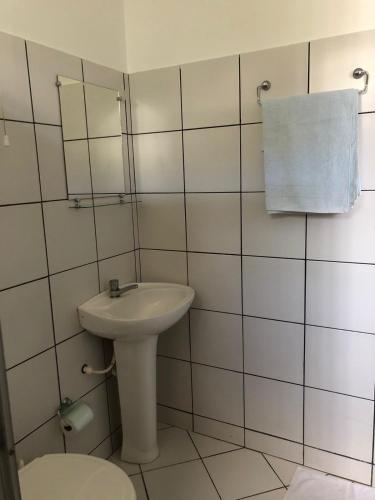 a white bathroom with a sink and a toilet at Pousada Irmão Sol Irmã Lua in Abadiânia