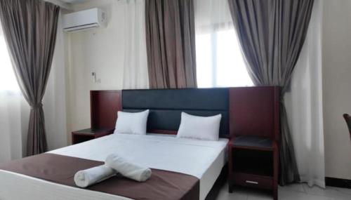 a bedroom with a bed with two towels on it at Melias Hotel Diamniadio in Dogar