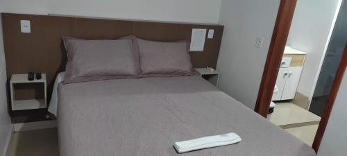 a bed with a white object sitting on top of it at Apartamento Central in Ametista do Sul
