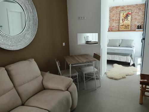 Una sala de estar con un sofá, una mesa y una cama. en WOWHOLIDAYS Magic Center Ronda, en Ronda