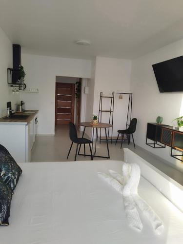 a bedroom with a white bed and a table and chairs at Nature bay in Pointe-à-Pitre