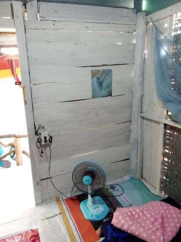 a small room with a fan and a wall at The Rock Hut in Ko Lanta