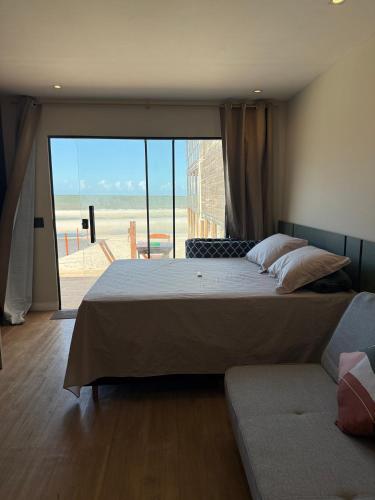 a bedroom with a large bed and a couch at Nossos Chalés de Praia in Bragança