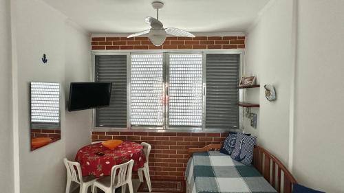 ein Raum mit einem Tisch und Stühlen und einem Fenster in der Unterkunft Apartamento Pé na Areia - Praia Grande in Praia Grande