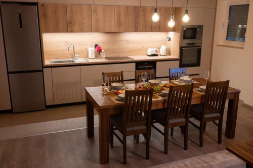 a kitchen with a wooden dining table and chairs at Sabljić Estate in Široki Brijeg