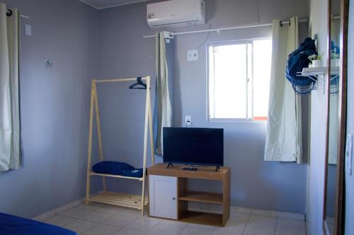 a living room with a tv and a table with a television at Apt com Ar Próx Hospital Unimed,Orla, Centro, Shopping, Restaurantes e Exército in Petrolina